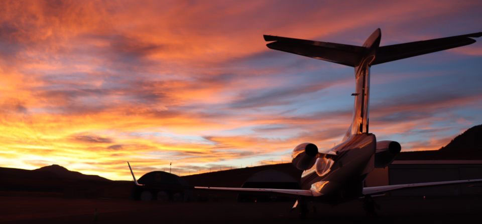 Airplane taking off runway at sunset