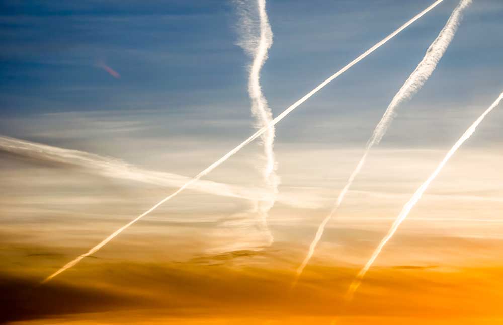 airplane exhaust trails after in-air flight training at a pilot school
