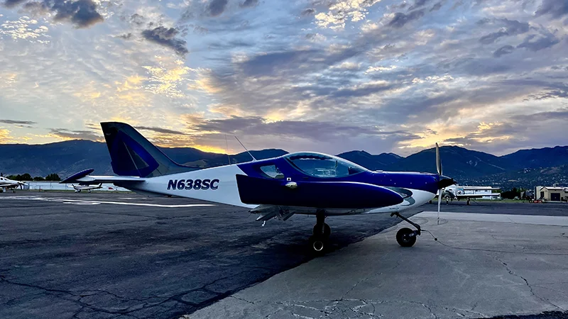 Small aircraft with clouds in background.