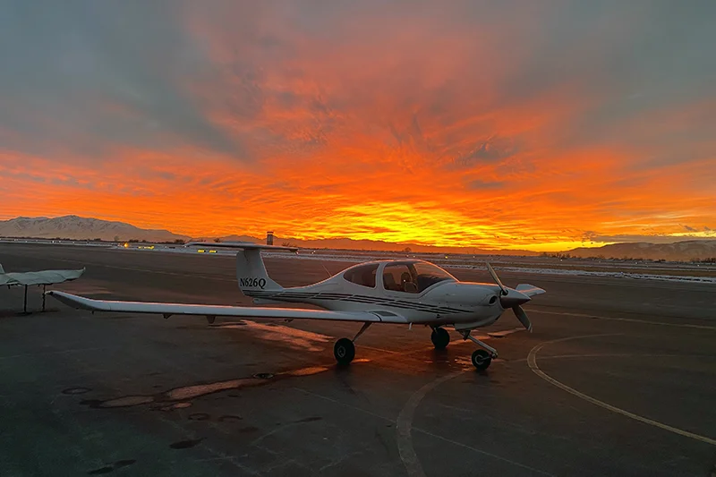 Small airplane in front of sunset.