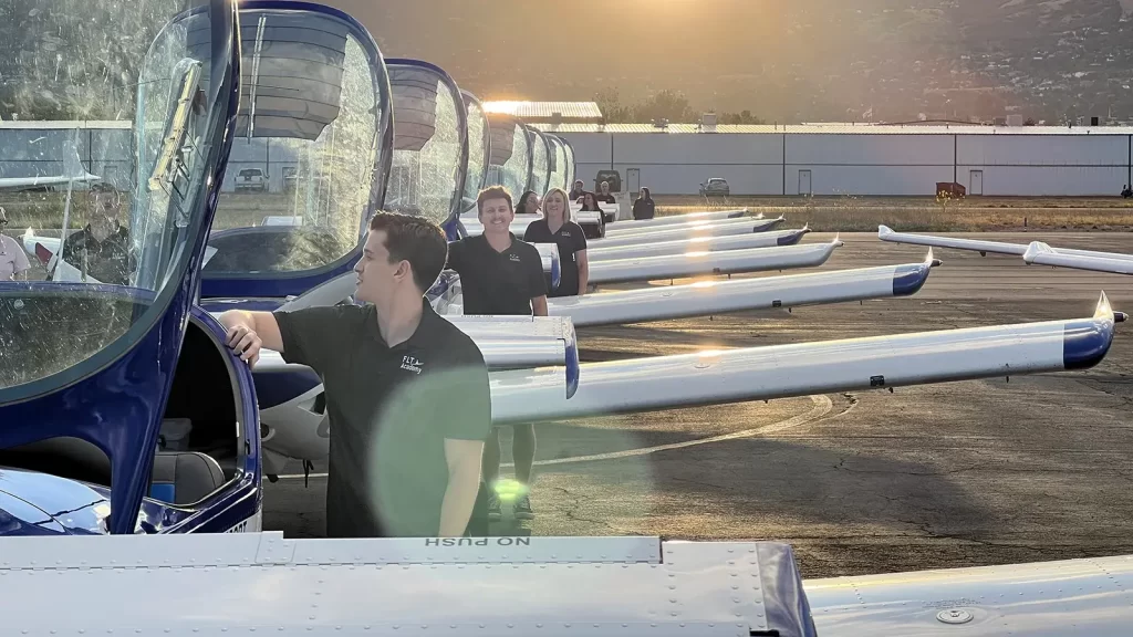Small aircraft and pilots on the tarmac.